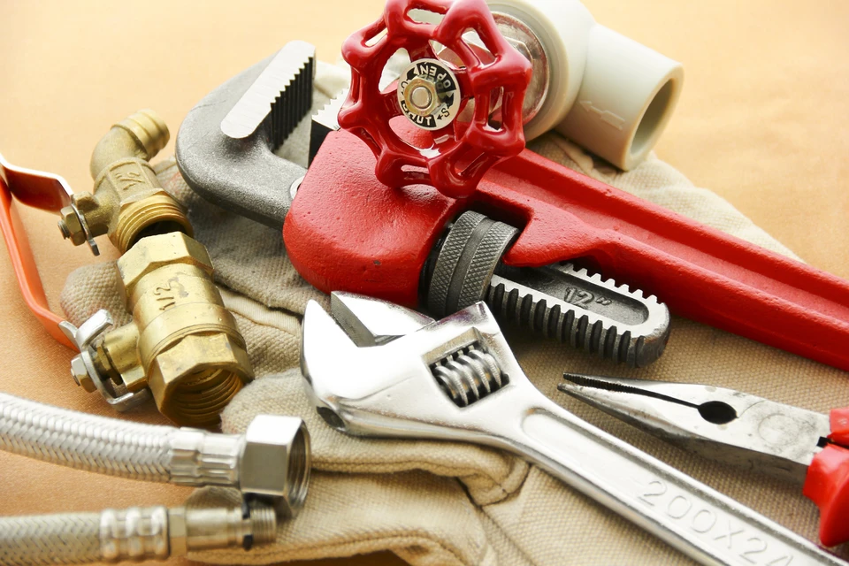 Atelier de plomberie avec outils professionnels disposés sur établi
