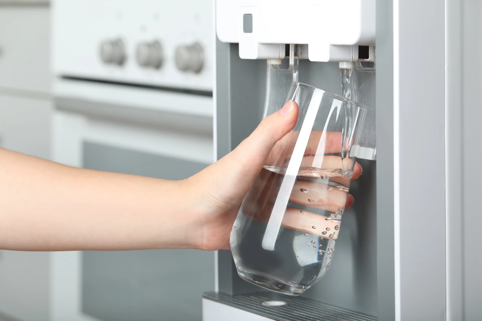Femme remplissant du verre avec un refroidisseur d'eau à l'intérieur, en gros plan