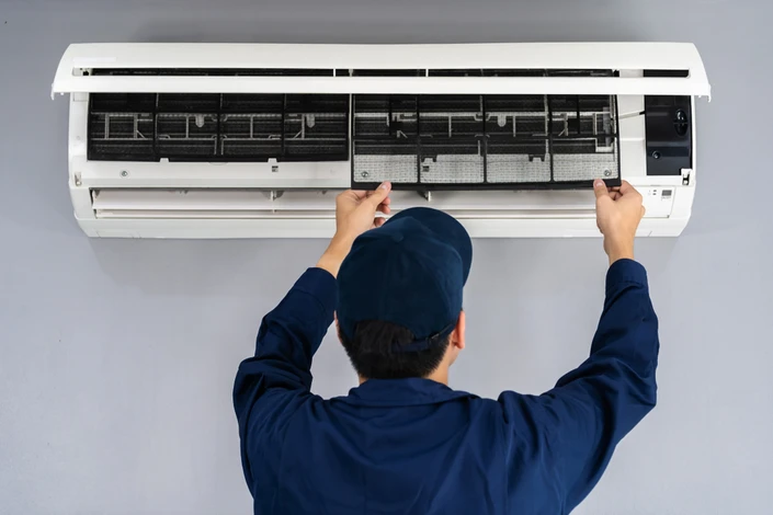 Extérieur d'un bâtiment avec unité de climatisation industrielle blanche à double ventilateur axial
