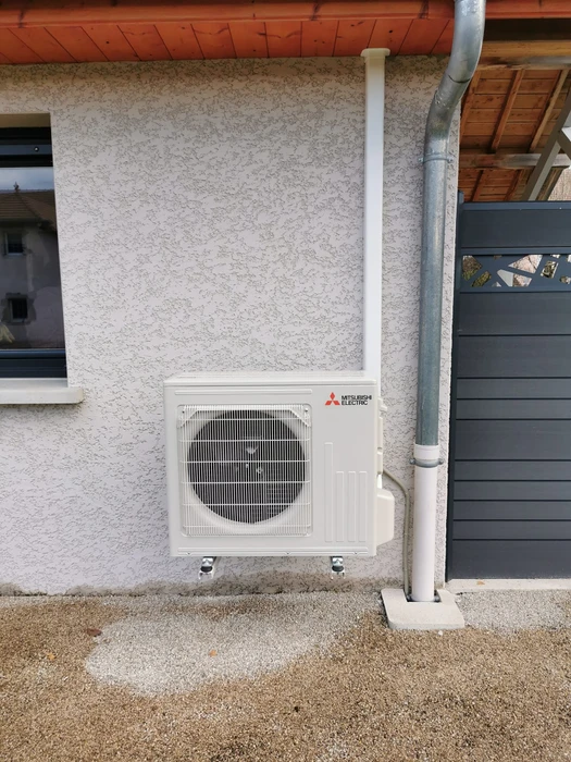 Extérieur résidentiel avec installation de pompe à chaleur air-eau sur dalle béton